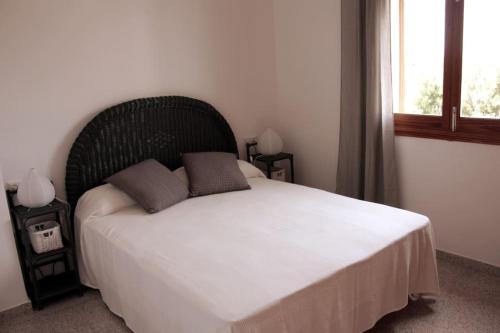 a bedroom with a large white bed with a large window at Bonito Chalet en Sa Ràpita in Sa Ràpita