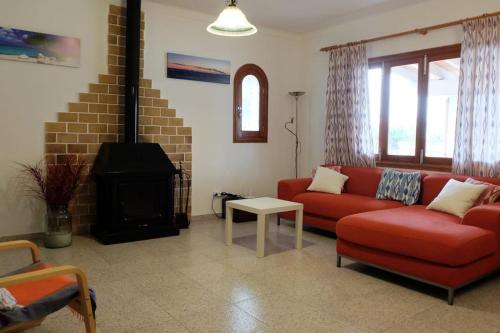 a living room with a red couch and a fireplace at Bonito Chalet en Sa Ràpita in Sa Ràpita