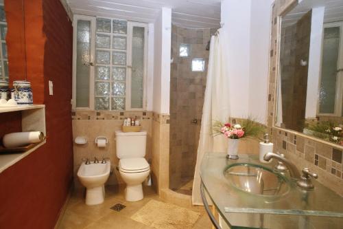 a bathroom with a toilet and a sink and a shower at La Casita de Yerba Buena in Marcos Paz