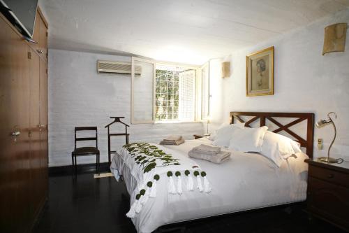 1 dormitorio con 1 cama blanca grande y ventana en La Casita de Yerba Buena en Marcos Paz