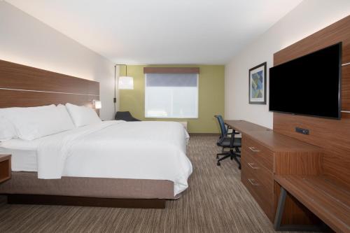 a hotel room with a bed and a flat screen tv at Holiday Inn Express Yreka-Shasta Area by IHG in Yreka