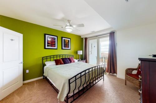een slaapkamer met een bed en een groene muur bij The Sanctuary - Roaring Sunset 230B in Virginia Beach