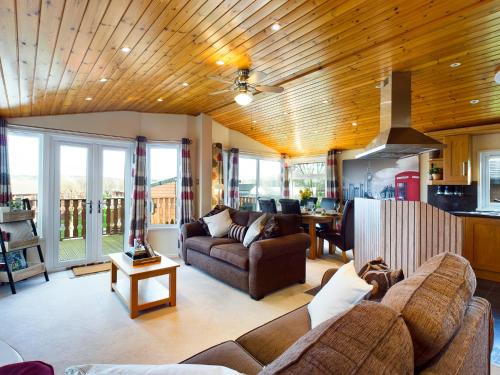 a living room with a couch and a table at 3 Bedroom Lakeview Lodge - Ensuite & Balcony Deck in Carnforth