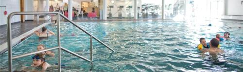 a group of children swimming in a swimming pool at 3 Bedroom Lakeview Lodge - Ensuite & Balcony Deck in Carnforth