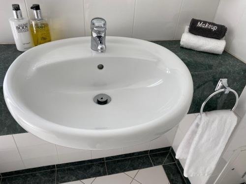 a white sink in a bathroom with a towel at Motel On York in Dunedin