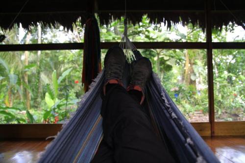 a person laying in a hammock with their feet up at Ecolucerna Lodge Tambopata in Puerto Maldonado