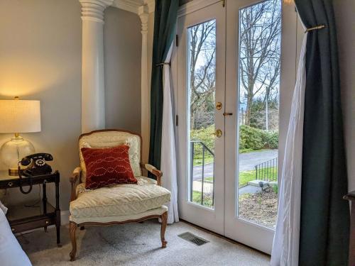 a room with a chair next to a sliding glass door at Stanton House Inn in Greenwich