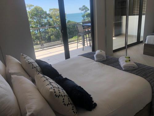 a bed in a room with a view of the ocean at Grand Mercure Allegra Hervey Bay in Hervey Bay