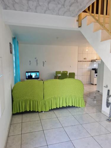 um quarto com uma cama verde num quarto em CHEZ VERVEINE em Saint-Laurent du Maroni
