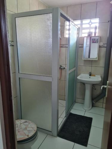 uma casa de banho com um chuveiro, um WC e um lavatório. em CHEZ VERVEINE em Saint-Laurent du Maroni