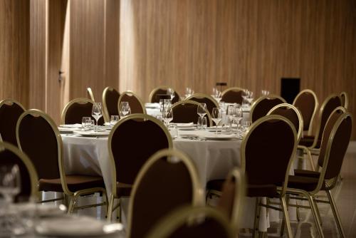 a room filled with tables and chairs with wine glasses at Gold Tower Lifestyle Hotel in Naples