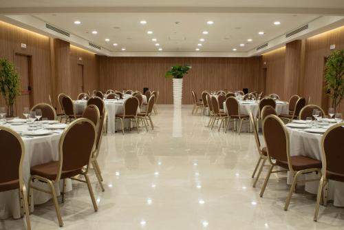 a banquet hall with white tables and chairs at Gold Tower Lifestyle Hotel in Naples