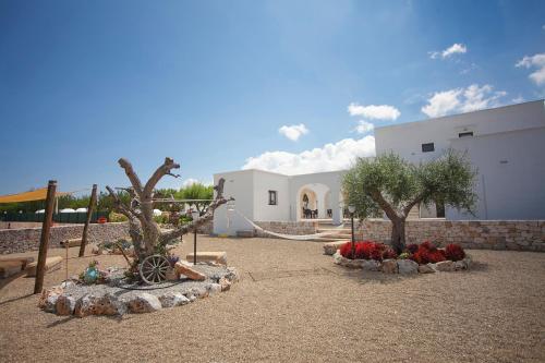 a courtyard with two trees and flowers and a building at Coppola di Seta in Locorotondo