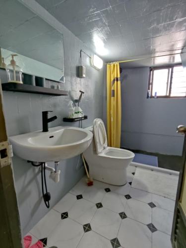 La salle de bains est pourvue d'un lavabo blanc et de toilettes. dans l'établissement 樓仔厝, à Île Lamay