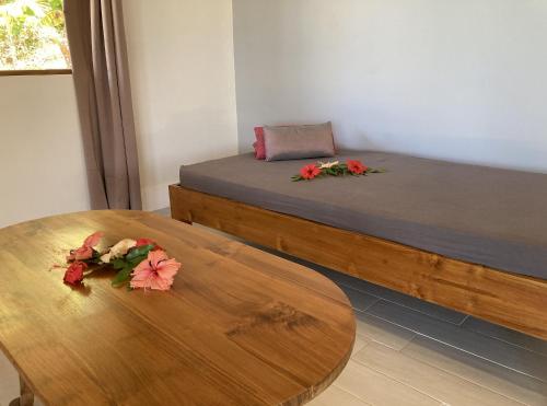 una habitación con 2 camas y una mesa con flores. en FARE ARIITEA, en Bora Bora