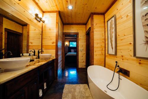 a bathroom with two sinks and a tub at Came Here to Forget Cabin in Broken Bow
