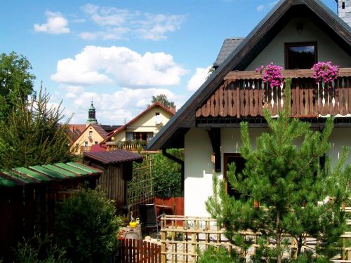 a house with a balcony with purple flowers on it at Stara Kuźnia in Sosnówka