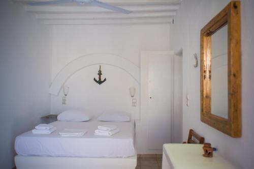 a white bedroom with a bed and a sink at Κymanemi Folegandros in Agali