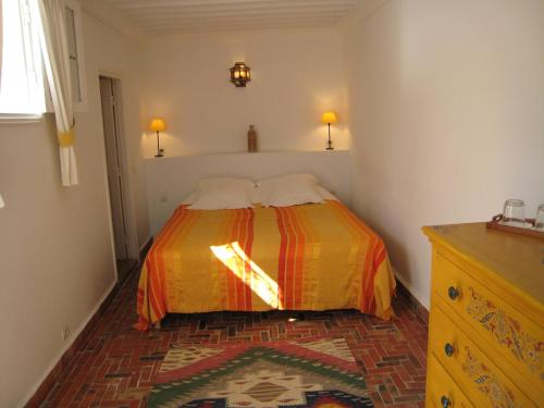 a bedroom with a bed with two pillows on it at Dar Ness in Essaouira