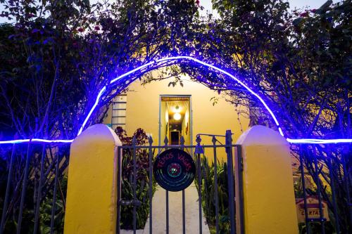 a gate with blue lights in front of a house at Hostel Gentileza - Guest House in Alto Paraíso de Goiás