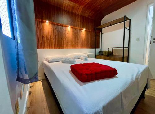 a bedroom with a bed with a red pillow on it at Descanso Ed. Timoneiro próximo orla in Maceió