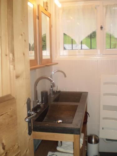 une cuisine avec un évier dans une petite maison dans l'établissement Appartement centre-ville au calme Grande Terrasse et Garage, aux Gets