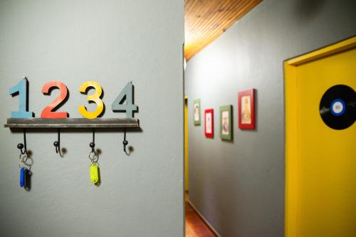 a wall with a shelf with numbers and handcuffs at Hostel Gentileza - Guest House in Alto Paraíso de Goiás