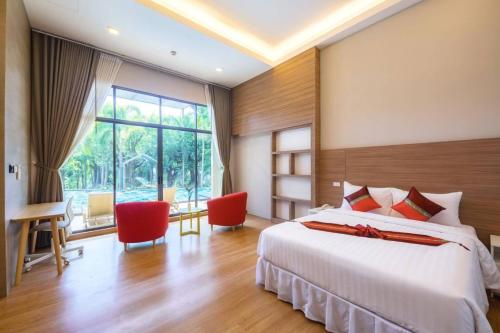 a bedroom with a large bed and a large window at Treescape Resort Chiangmai in Chiang Mai