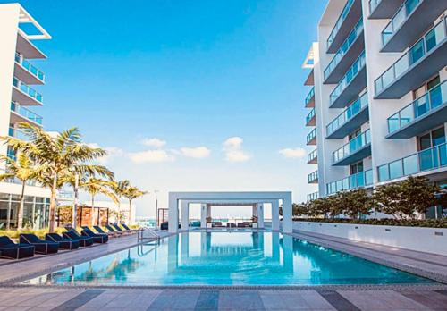 a swimming pool in front of a building at Sleek 2BD 2BA Condo In Miami Design District in Miami