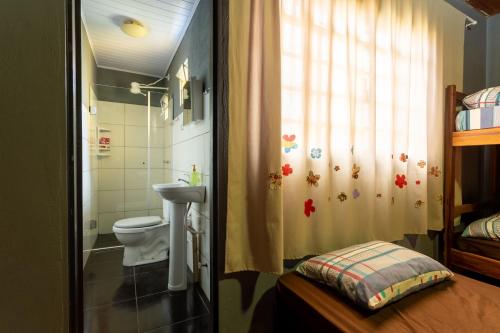 a bathroom with a toilet and a sink and a shower at Hostel Gentileza - Guest House in Alto Paraíso de Goiás