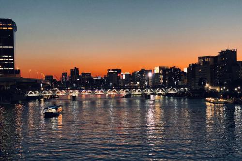 a boat in the water in a city with a bridge at TOE LIBRARY Tokyo Asakusa in Tokyo