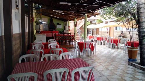 a restaurant with red and white tables and chairs at Recanto do Carreiro in Trindade