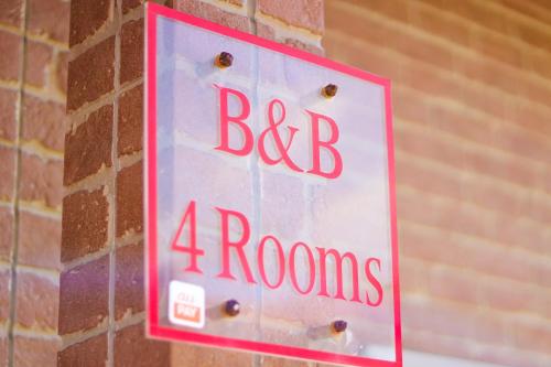 a sign on a brick wall that says big rooms at B&B 4 Rooms in Naha