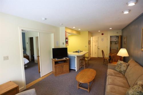ein Wohnzimmer mit einem Sofa und einem Tisch in der Unterkunft Inns Of Wv 205, 1bd, Waterville Valley in Waterville Valley