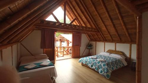 a bedroom with two beds and a large window at Villa Ester Hostel Vereda Cay in Ibagué