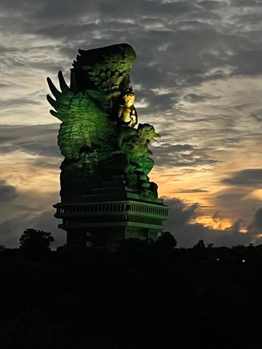 a statue of an eagle with a sunset in the background at PINOKKIO B&B Restaurant in Jimbaran