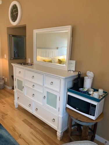 a white dresser with a mirror and a microwave on it at Salish B&B and Spa in West Kelowna