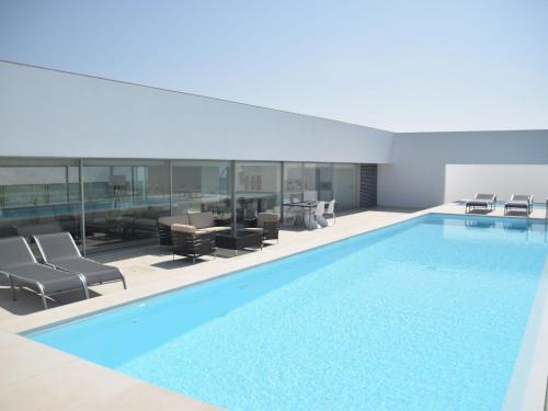 una gran piscina con sillas y una mesa en Modern Villa in bidos Lisbon with garden and pool, en Vau