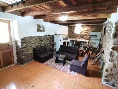 sala de estar con muebles y pared de piedra. en APARMENT SAMANA HOUSE OLLANTAYTAMBO, en Ollantaytambo