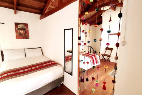 1 dormitorio con 1 cama y algunas decoraciones en la pared en APARMENT SAMANA HOUSE OLLANTAYTAMBO, en Ollantaytambo