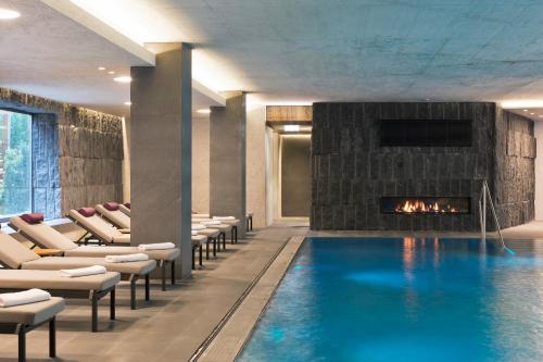 a swimming pool with chairs and a fireplace at ElisabethHotel Premium Private Retreat- Adults only in Mayrhofen