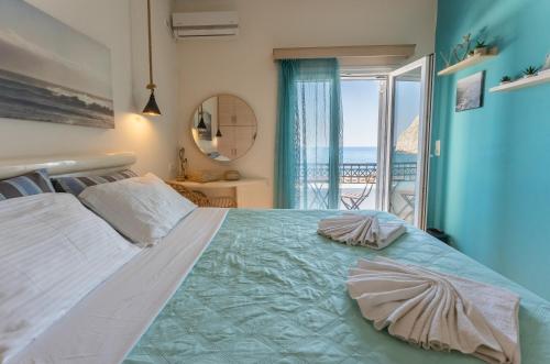a bedroom with a large bed with a view of the ocean at Sagma calm apartment with amazing sea view in Perissa