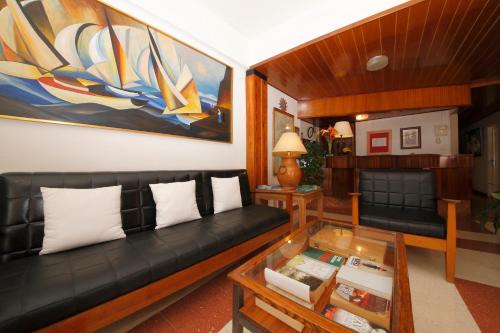 a living room with a black couch and a glass table at Hotel Edén in Los Llanos de Aridane