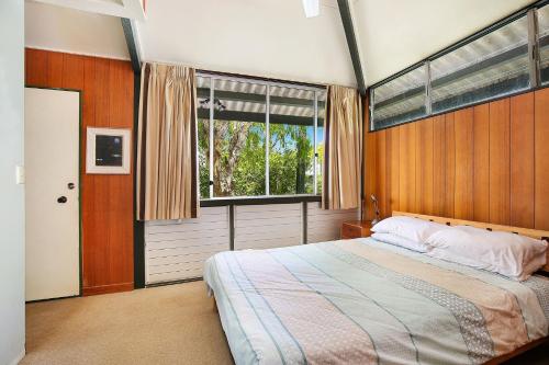 um quarto com uma cama e uma grande janela em Ngungun St 14 Dicky Beach em Caloundra