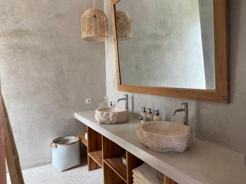 a bathroom with two sinks and a mirror at Villa Biarritz in Uluwatu