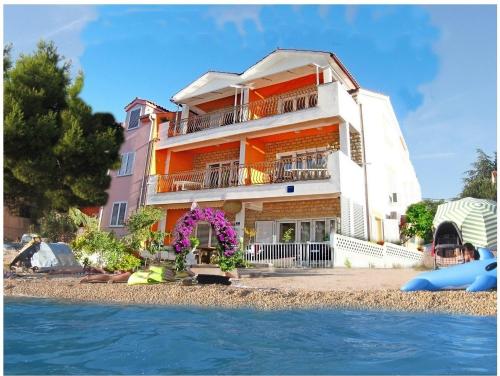 a building on the beach next to the water at Villa Aurelia Vodice in Vodice