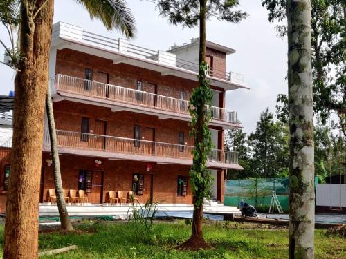 a large brick building with a balcony at DOLPHIN ENCLAVE SERVICE STUDIO APARTMENTS in Kalpetta