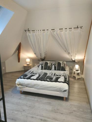 - une chambre avec un grand lit et des rideaux dans l'établissement Le pâtureau d'en haut, à Gièvres