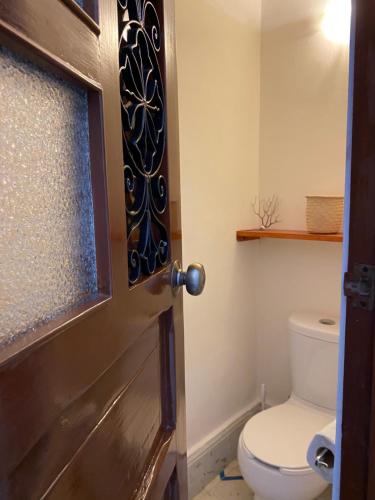 a bathroom with a toilet and a door at Hotel La Piazzetta in Mérida