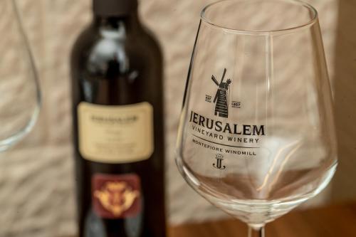 a bottle of wine next to a wine glass at Montefiore Hotel By Smart Hotels in Jerusalem